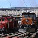 Devant la remise, deux petites crocodiles, la Ge 6/6 I 415 du RhB sur un truck porteur et la De 6/6 15301 du Seetal